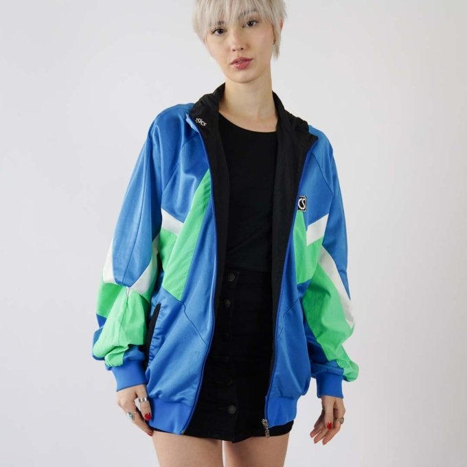 Veste Asics sportswear vintage vert menthe et bleu clair, bordures noires, coupe unisexe avec poches latérales, style streetwear inspiré des années 90.