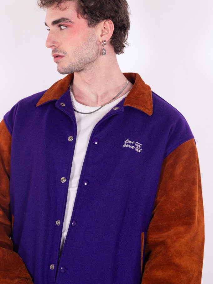 Bomber Varsity Hard Rock Café New Orleans en laine violet et manches cuir camel, broderie "Love all Serve all" et patch logo emblématique - détail broderies avant