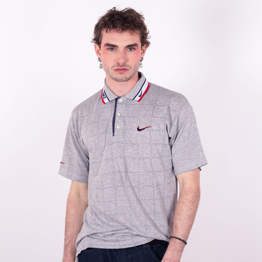 Polo Nike vintage des années 90 en gris avec quadrillage graphique, col liseré blanc sport wear, swoosh bicolore brodé et motif Nike répété - face
