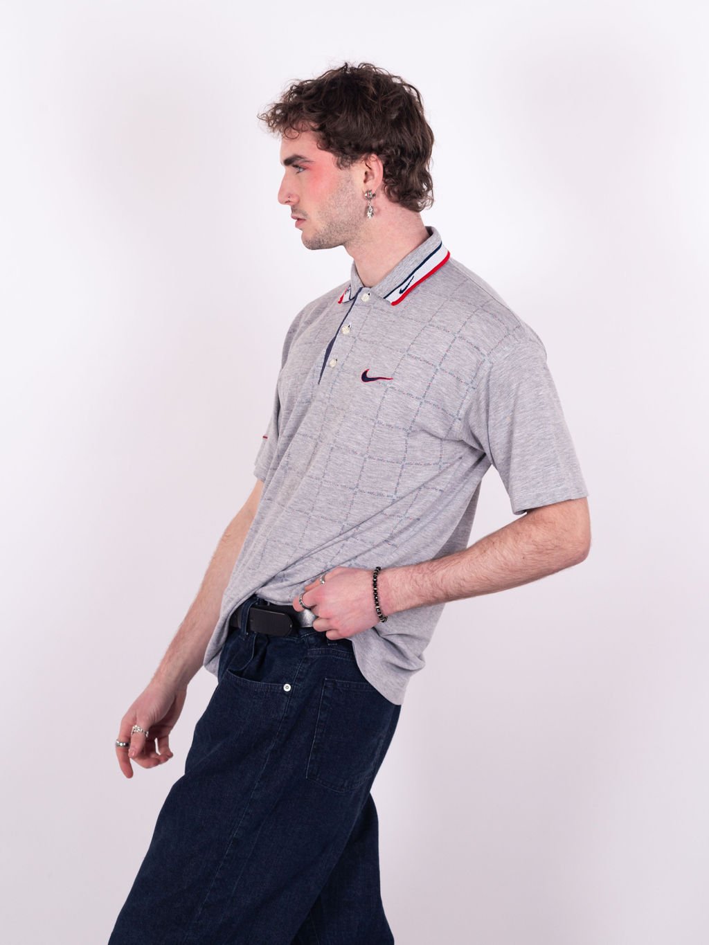 Polo Nike vintage des années 90 en gris avec quadrillage graphique, col liseré blanc sport wear, swoosh bicolore brodé et motif Nike répété - profil