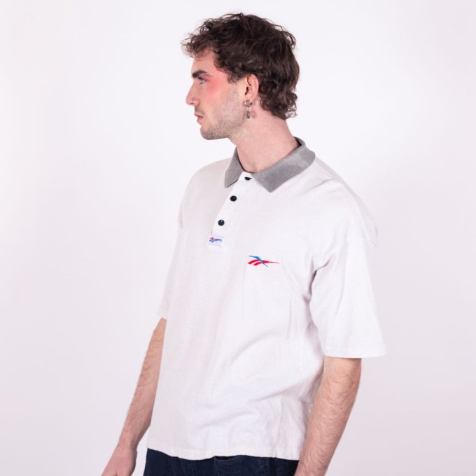 Polo Reebok vintage blanc texturé avec logo brodé rouge et bleu, col gris contrastant, coupe oversize et tissu épais - profil