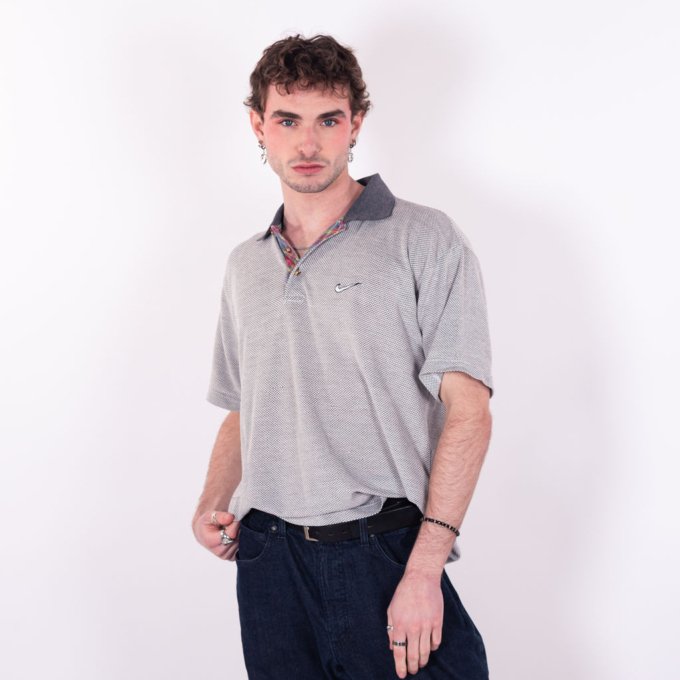 Polo vintage Nike des années 90 en coton épais avec swoosh brodé en fil gris, col en gris anthracite et motif tartan écossais sur la doublure d'ouverture - face
