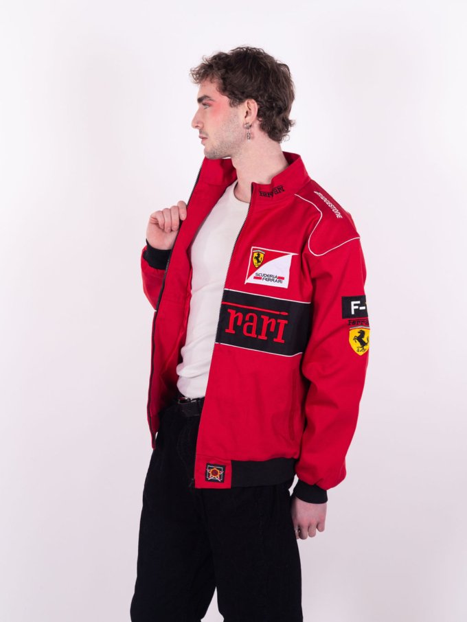 Veste Ferrari vintage rouge et noire signée JH Design avec logos brodés Puma, UPS, Scuderia et Bridgestone, cheval Ferrari bordé en noir au dos - profil